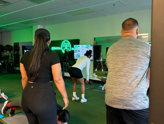 Clients participating in a guided group workout session at Ferris Fitness in Duluth, GA, with trainers providing support and motivation in a modern indoor gym.